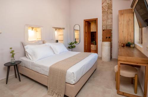 a bedroom with a large white bed and a table at Pavlina Villa , a hidden gem with heated pool and ping pong! in Perama