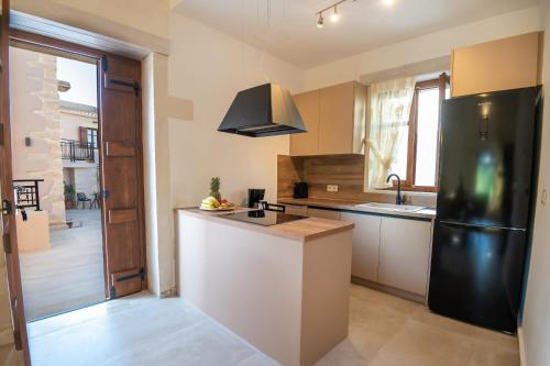 a kitchen with a black refrigerator and a sink at Pavlina Villa , a hidden gem with heated pool and ping pong! in Perama