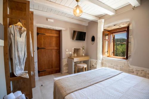 a bedroom with a bed and a desk and a window at Pavlina Villa , a hidden gem with heated pool and ping pong! in Perama