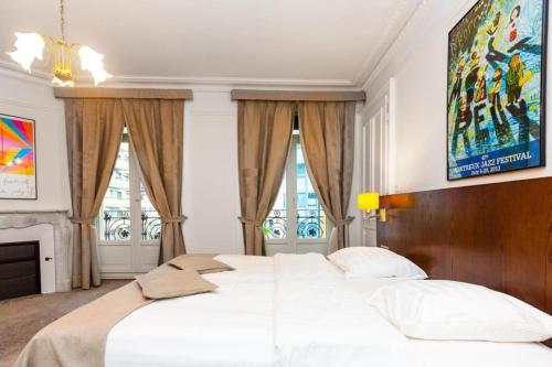 a bedroom with a large white bed and two windows at J5 Hotels Helvetie & La Brasserie in Montreux
