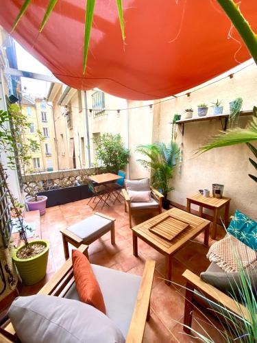 un patio extérieur avec tables, chaises et plantes dans l'établissement Appartement luxe terrasse climatisation centre d Aix, à Aix-en-Provence