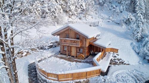 a log cabin in the snow with snow at Chalet Haarberg in Golling an der Salzach