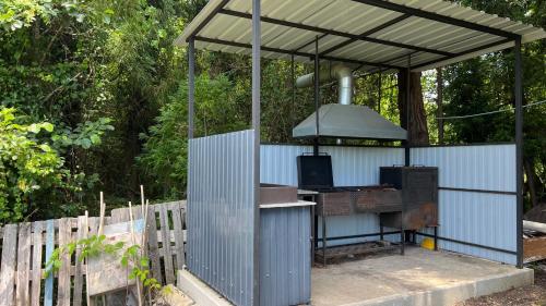 Una parrilla al aire libre con un toldo sobre una cerca en Magnetiti, en Ureki