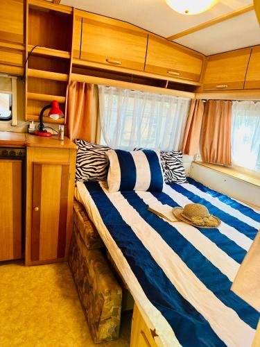 a large bed in the middle of a room at Каравана Синята Маймуна плаж Градина # RV Blue Monkey on the beach in Chernomorets