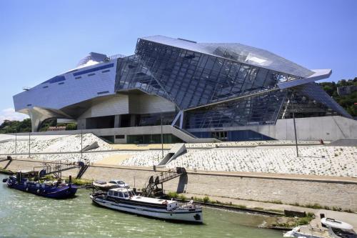 a building with boats in the water in front of it at Ibis Budget Lyon Est Saint Quentin Fallavier in Saint-Quentin-Fallavier
