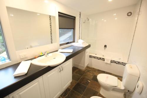 a white bathroom with a sink and a toilet at Points South By The Sea in Apollo Bay