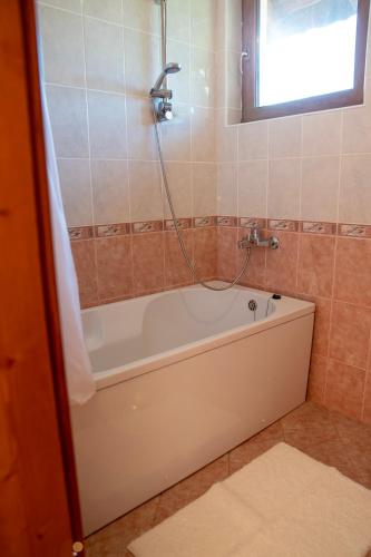 a bathroom with a bath tub with a shower at Къща за гости Далинда in Byala