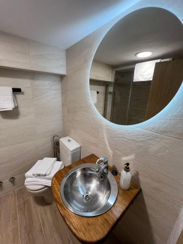 ein Badezimmer mit Waschbecken und Toilette mit Spiegel in der Unterkunft MartinVidal 1 in Luarca