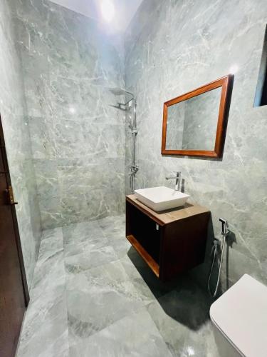 a bathroom with a sink and a mirror at Sound Sleep Resort in Arugam Bay
