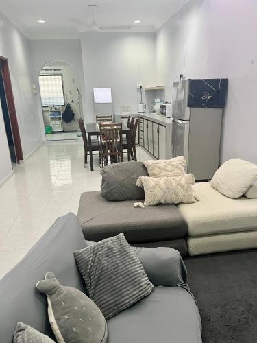 a living room with two beds and a kitchen at Aqua Shelter in Mersing