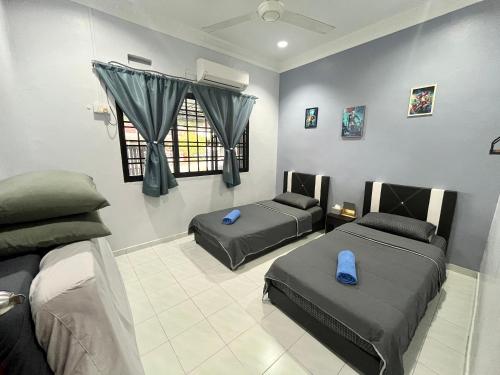 a room with two beds and a window at Aqua Shelter in Mersing