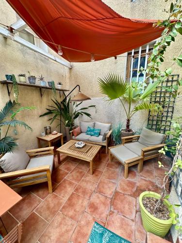 un patio extérieur avec tables, chaises et plantes dans l'établissement Appartement luxe terrasse climatisation centre d Aix, à Aix-en-Provence