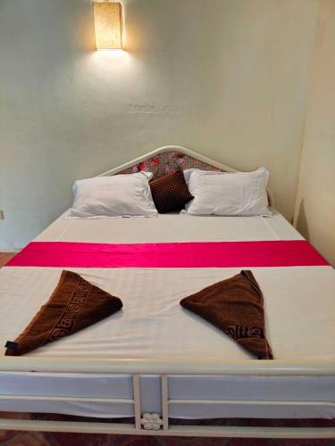 a bed with two pillows on top of it at Jungle House Kep in Kep