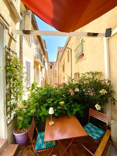 d'un balcon avec une table, des chaises et des plantes. dans l'établissement Appartement luxe terrasse climatisation centre d Aix, à Aix-en-Provence