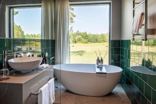 a bathroom with a large tub and a large window at Stufvenäs Gästgifveri in Söderåkra