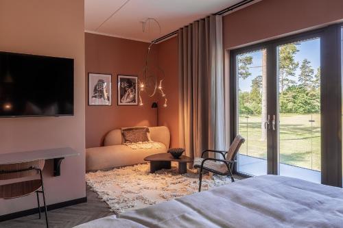 a bedroom with a bed and a couch and a tv at Stufvenäs Gästgifveri in Söderåkra