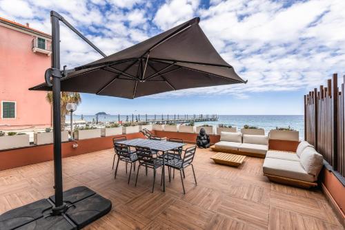 a patio with a table and chairs and an umbrella at ReMia Suites & Leisure in Alassio