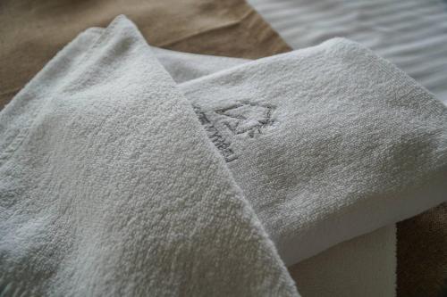 a white towel sitting on top of a bed at Leśny Wierch luxury spa villas in Bukowina Tatrzańska