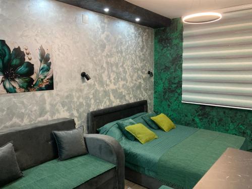 a bedroom with a bed and a couch with yellow pillows at Apartman Aleksandar 2 in Nova Varoš