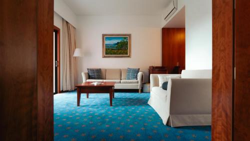 a living room with a couch and a table at BIO Hotel - Hotel Quinta da Serra in Estreito de Câmara de Lobos