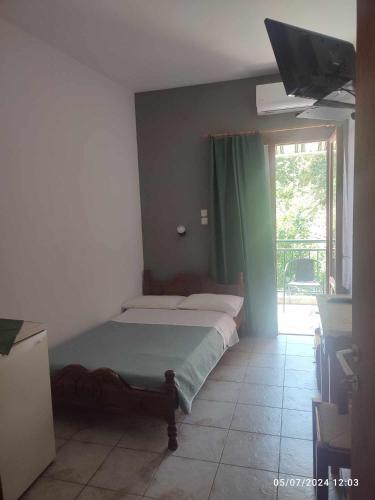 a bedroom with a bed and a window at Nissaki Guesthouse in Keramídhion