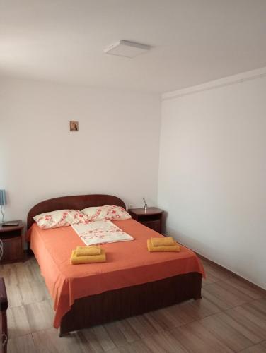 a bedroom with a bed with two yellow towels on it at Casa Eliza in Corbu