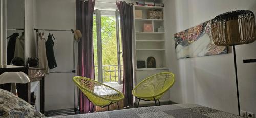 une chambre avec deux chaises jaunes et une fenêtre dans l'établissement Joli 2 pièces, chambre sur jardin arboré, à Paris
