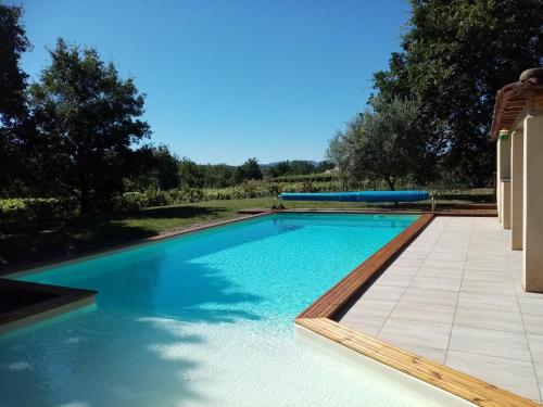 une piscine avec de l'eau bleue dans une cour dans l'établissement les chênes, à Rosières