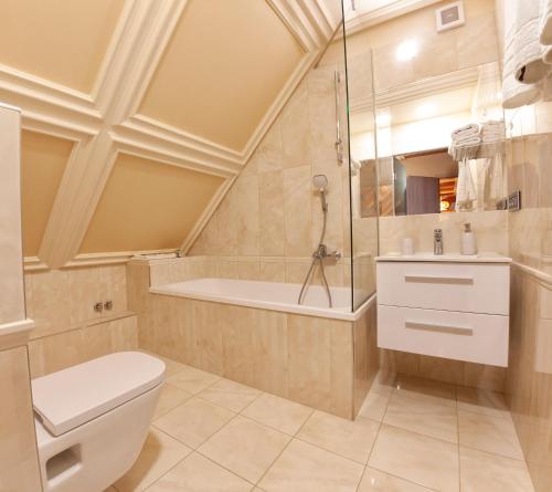a bathroom with a toilet and a bath tub at Villa Quality Wellness in Dozmat