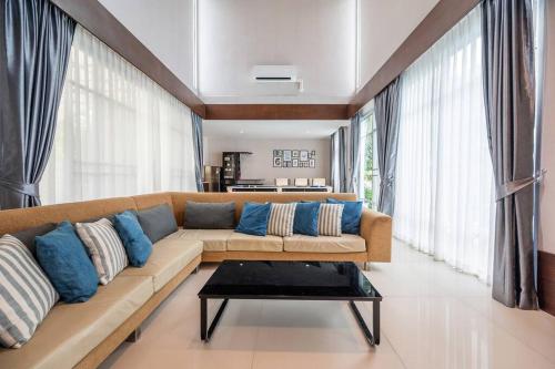 a living room with a couch with blue pillows at Sorrento Pool Villa Naga Jomtien Pattaya in Na Jomtien