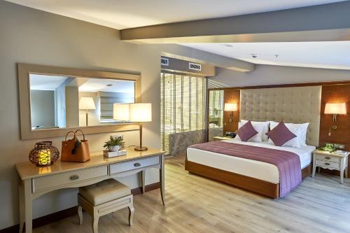 a bedroom with a bed and a desk and a mirror at Renata Boutique Hotel Sisli in Istanbul