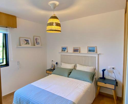 a bedroom with a bed and a pendant light at Apto 2D en primera línea de Playa Langosteira con garaje y wifi in Finisterre
