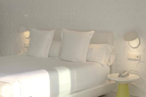 a bedroom with a white bed with white pillows at The Donna Portals in Portals Nous