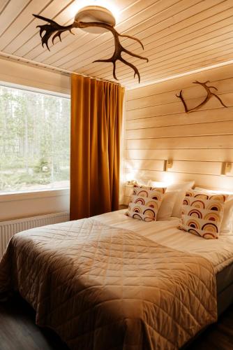 a bedroom with a large bed with a window at Aito Igloo & Spa Resort in Rovaniemi
