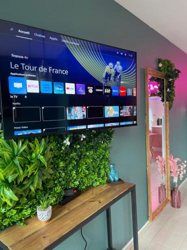 una TV a schermo piatto appesa a una parete di Maison Spacieuse Jacuzzi Wifi Netflix a Quiévrechain