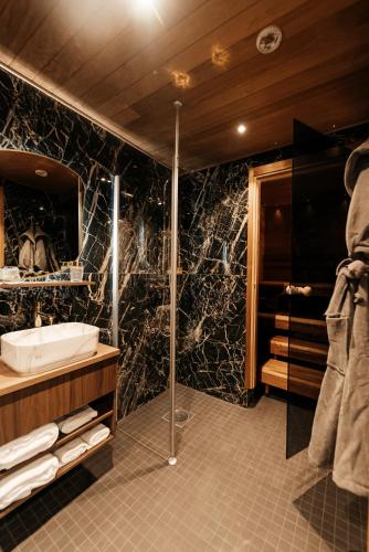 a bathroom with a shower and a sink and a tub at Aito Igloo & Spa Resort in Rovaniemi