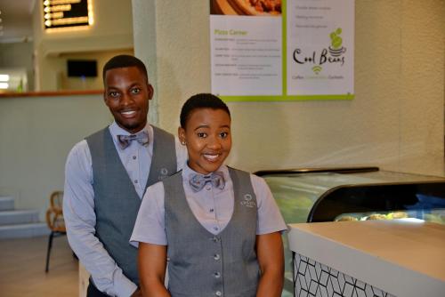 a man and a woman standing next to a counter at Cresta Lodge Harare in Harare