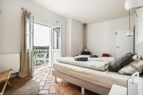 a bedroom with two beds and a large window at Casa Kalu in São Brás de Alportel
