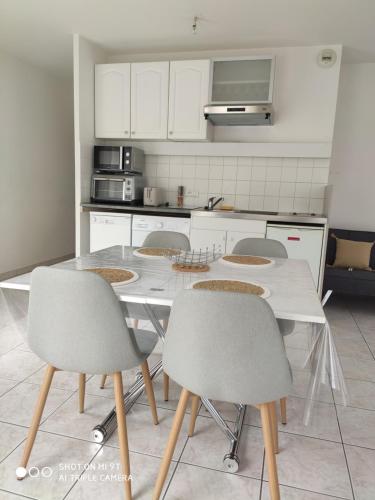 une cuisine avec une table et des chaises dans une cuisine dans l'établissement Sublime T2 LUMINEUX avec Balcon - rue gratuite, à Amiens