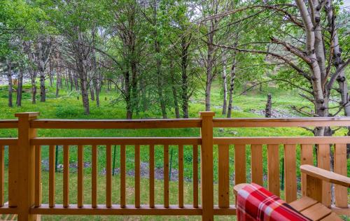 a wooden bench on a porch with a view of a park at 1740 Boutique Hotel Kazbegi in Stepantsminda