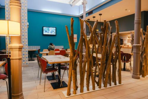 a restaurant with tables and chairs and a blue wall at Comfort Aparthotel Saint-Etienne in Saint-Étienne