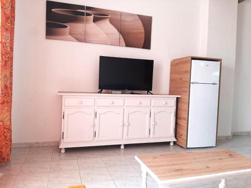 a white cabinet with a television on it next to a refrigerator at APCOSTAS - Complejo Al Andalus in Alcossebre