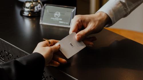a person handing another person a piece of paper at Molokan Inn Hotel in Baku