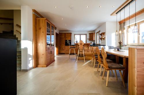a kitchen with wooden cabinets and a table and chairs at Bauernhaus Chalet Unterkoller in Bischofshofen