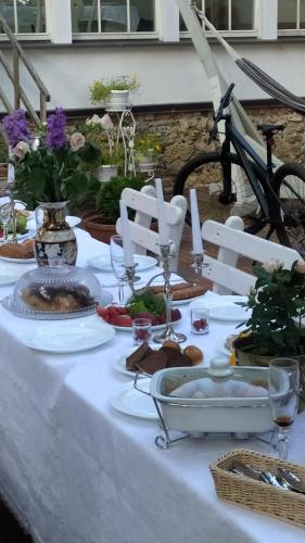 a table with a white table cloth with food on it at Jumpravas pils in Jumprava