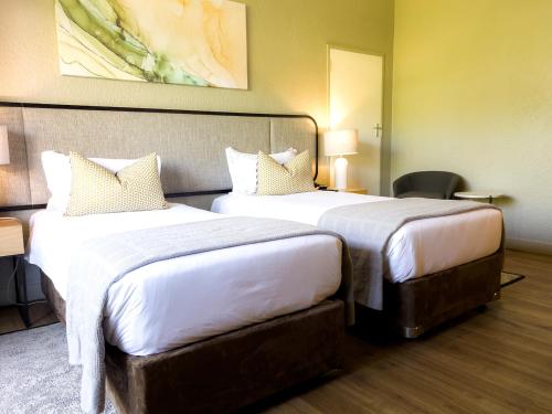 a hotel room with two beds in a room at Cresta Lodge Harare in Harare