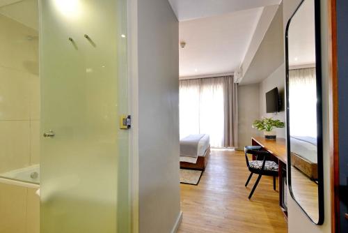 a room with a bedroom and a desk with a bed at Cresta Lodge Harare in Harare