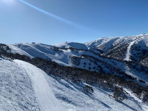 a group of people skiing down a snow covered mountain at Higgi Drive 1 Ski-In Ski-Out in Mount Hotham