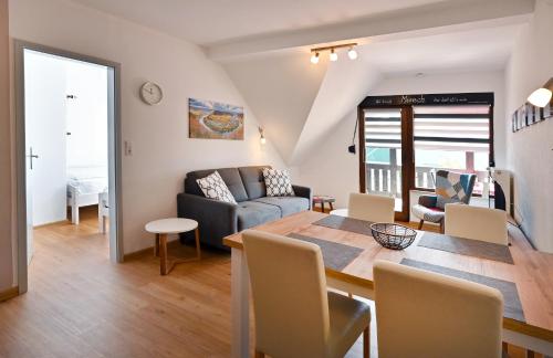a dining room and living room with a table and a couch at Ferienwohnungen by Weingut Hommes in Ernst Mosel in Ernst