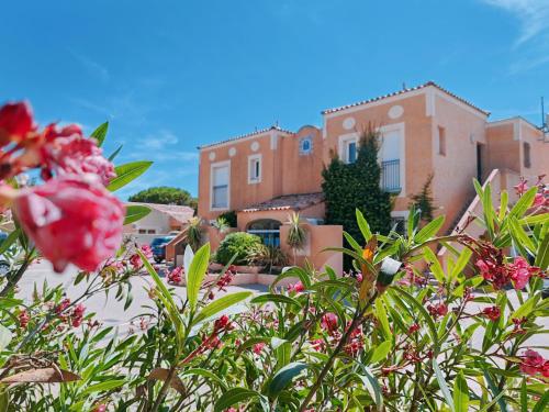 a group of flowers in front of a building at Résidence l'Oustal des Mers in Gruissan